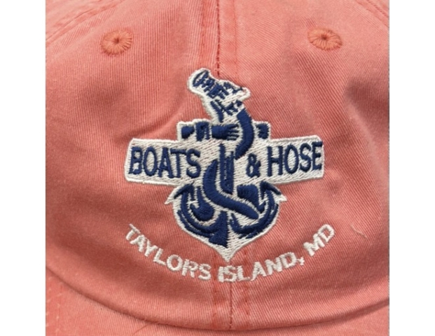 Boats and Hose Coral pink hat with navy and white embroidery reading Boats and Hose, Taylor Island, MD. Anchor and hose logo in center.