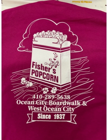 Fisher's Popcorn Red garment screen printed in white ink with text reading Fisher's Popcorn, phone number, Ocean City Boardwalk & West Ocean City, Since 1937. Logo includes image of box of popcorn on wood surface boardwalk.