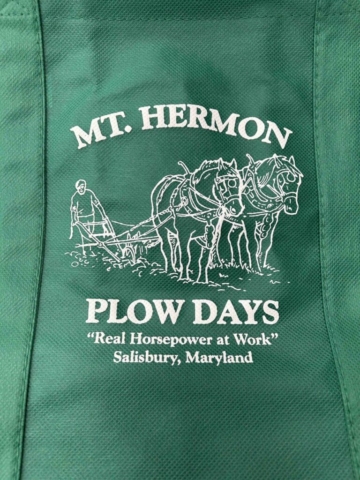 Mt. Hermon Plow Days Emerald green tote bag with white screen print of image of person plowing with two draft horses. Text reads Mt. Hermon Plow Days - Real horsepower at work, Salisbury, MD.