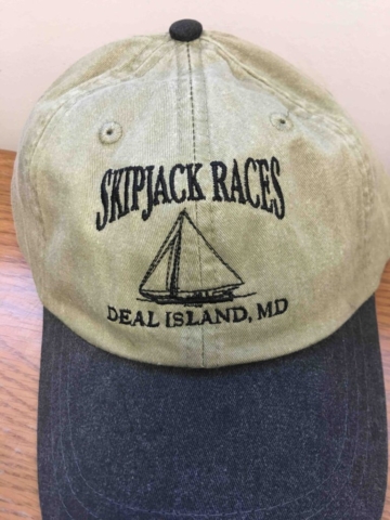 Skipjack Races Tan hat with blue denim brim. Embroidered logo reads in black thread Skipjack Races - Deal Island, MD. Embroidery of skipjack vessel in center.